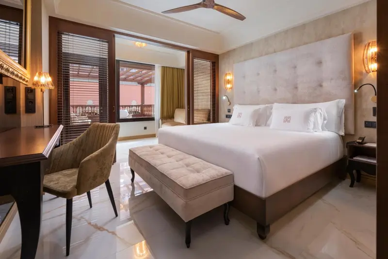 Une chambre lumineuse avec un grand lit et un coin salon.