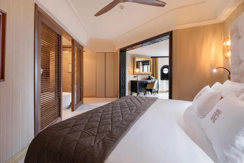 Une chambre à coucher lumineuse avec un grand lit et un accès à une salle de bain.