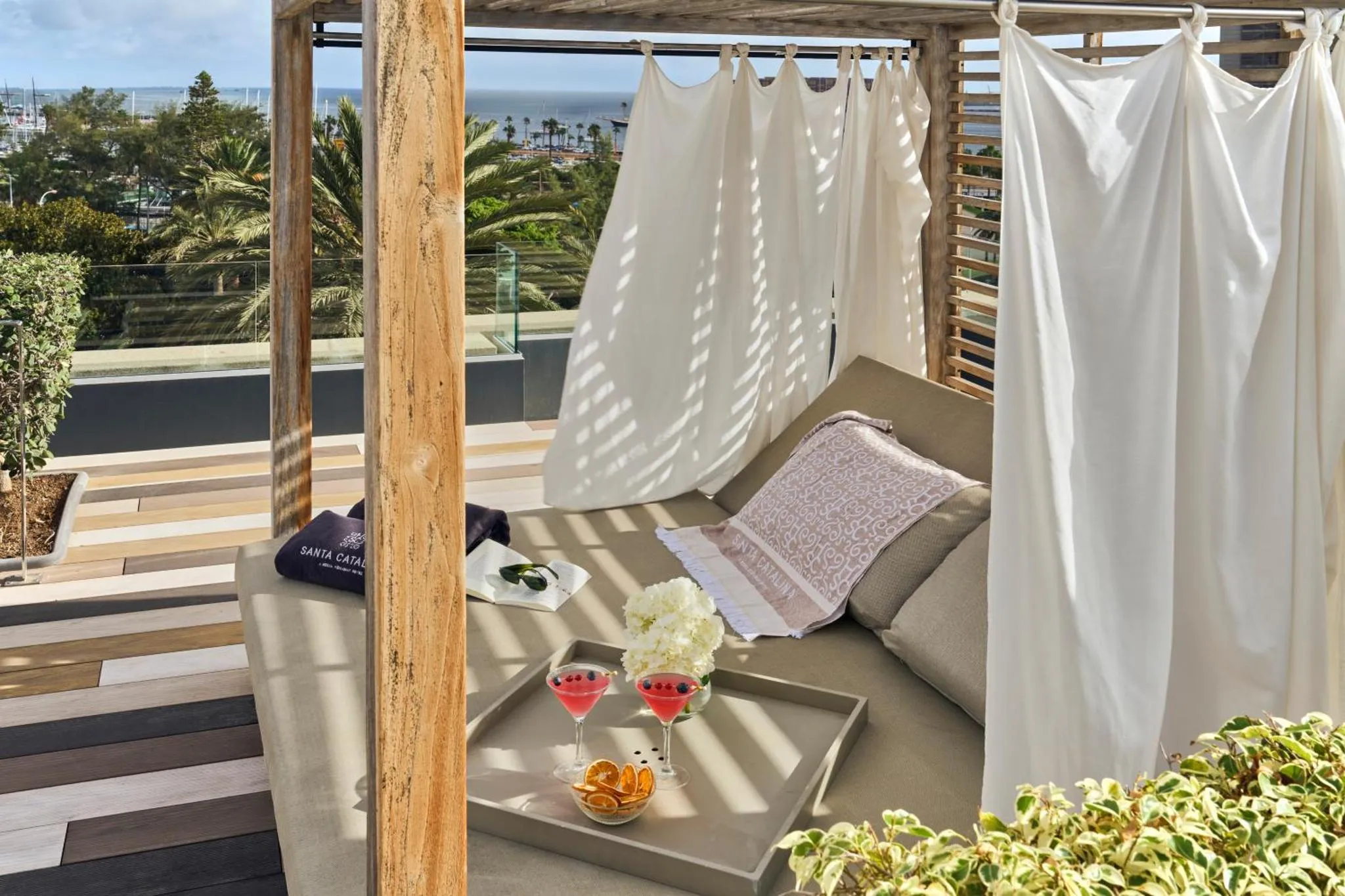 Espace de détente extérieur avec canapés et vue sur la mer.