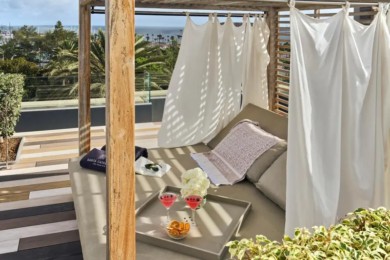 Espace de détente extérieur avec canapés et vue sur la mer.
