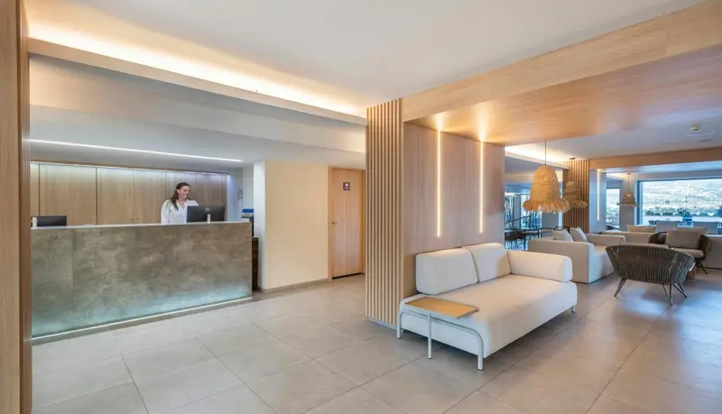 Un comptoir d'accueil moderne dans un hall d'hôtel lumineux.