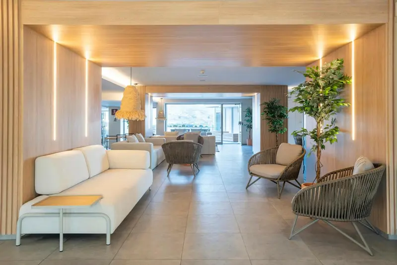 Espace de détente intérieur avec canapés et fauteuils clairs.
