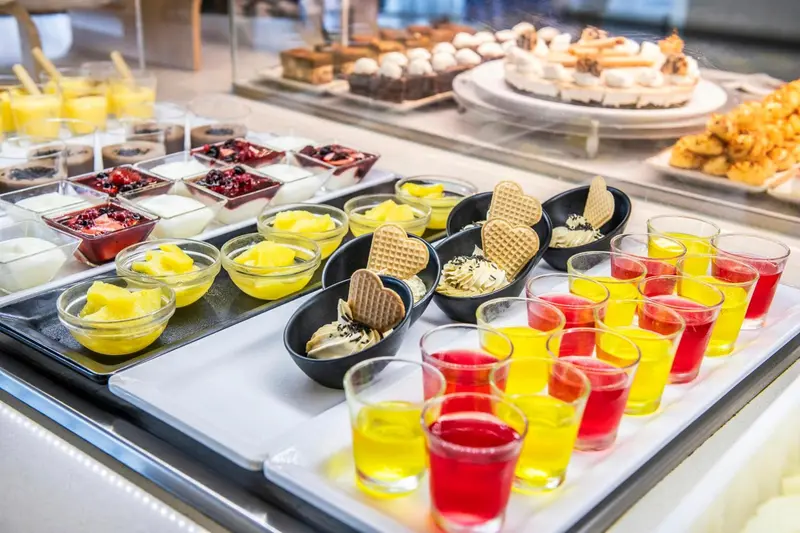 Présentation de desserts variés et de boissons colorées sur un buffet.