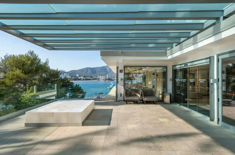 Terrasse ombragée avec mobilier d'extérieur donnant sur la mer.