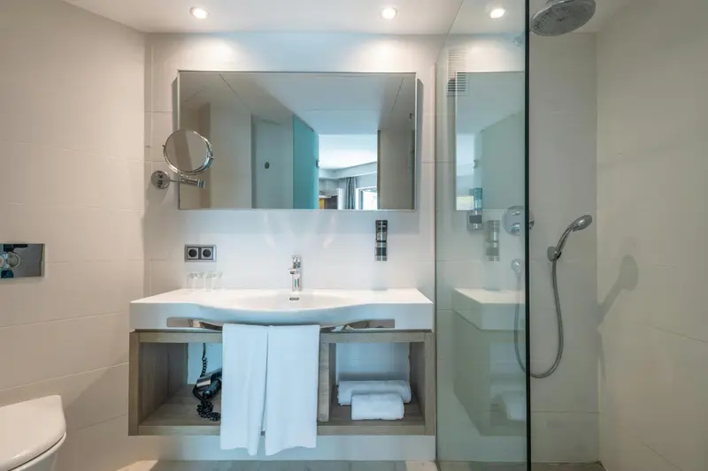 Une salle de bain moderne avec douche à l'italienne et grand miroir.