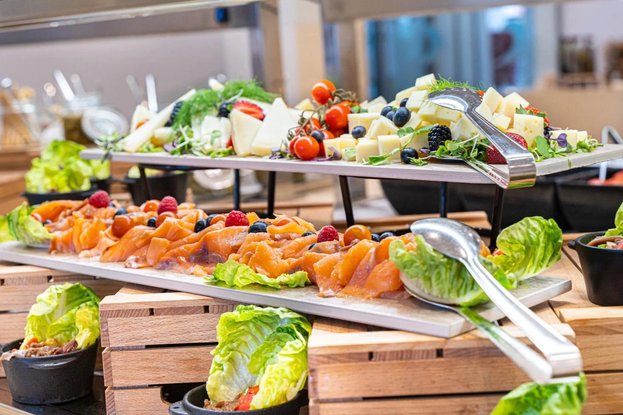Un buffet propose une variété de salades, de fruits et de charcuteries.