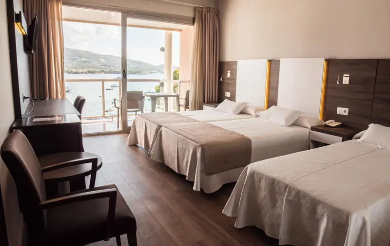 Une chambre lumineuse avec un grand lit et une vue sur la mer.