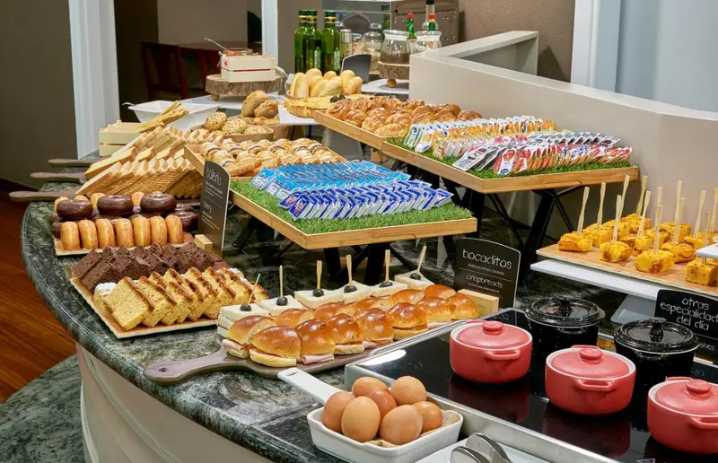 Un buffet propose une grande variété de viennoiseries, de pâtisseries et de fruits.