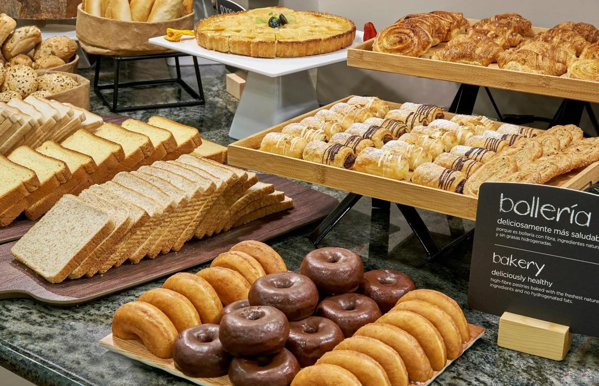 Présentation de viennoiseries et de pâtisseries sur un buffet.