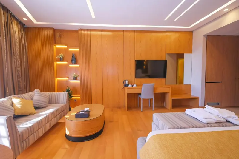 Espace de vie intérieur lumineux avec canapé, bureau et lit.