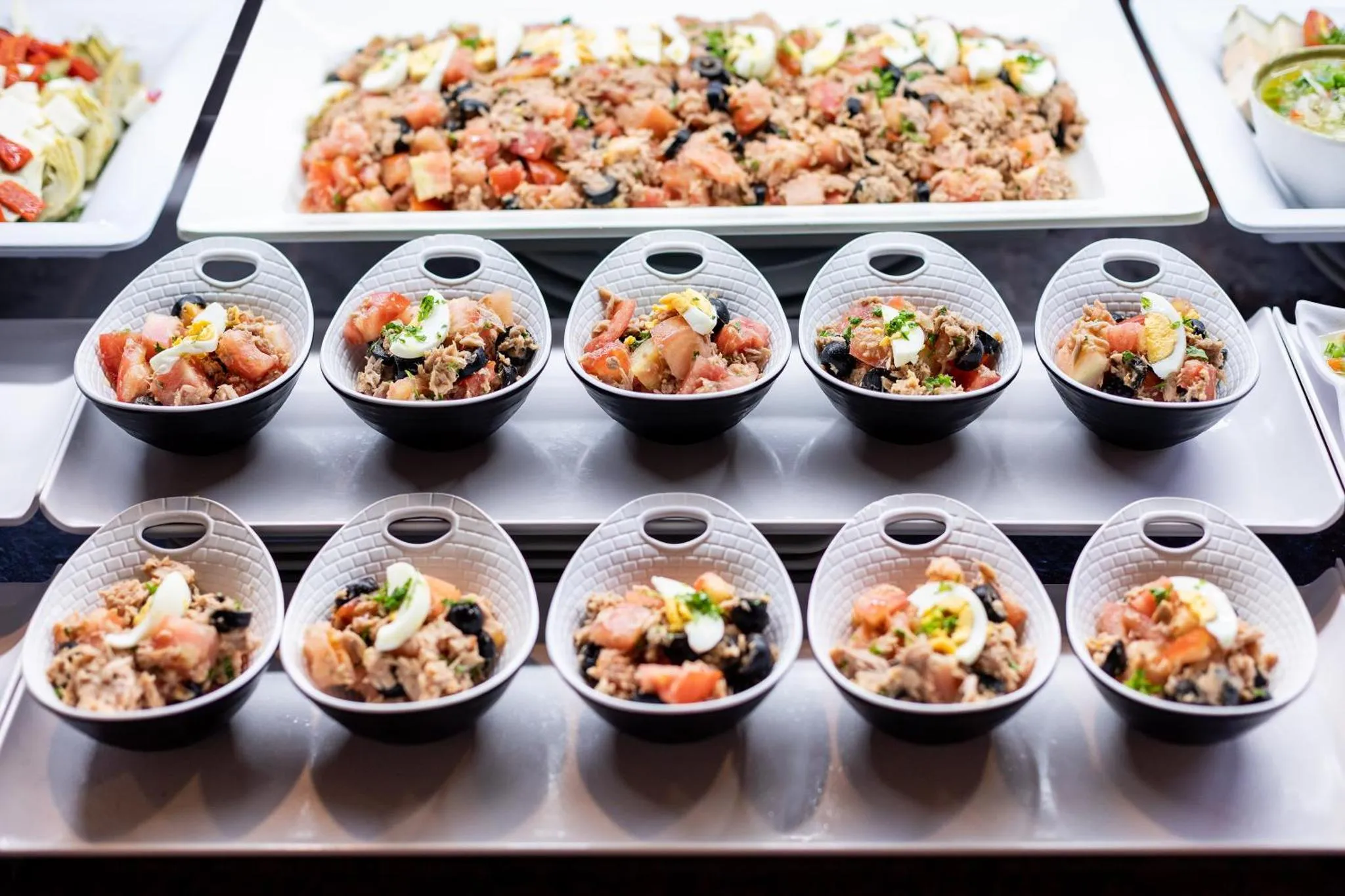 Présentation de salades composées et de petites portions individuelles sur un buffet.