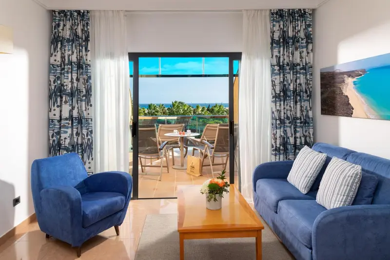 Un salon lumineux s'ouvre sur une terrasse avec vue sur la mer.