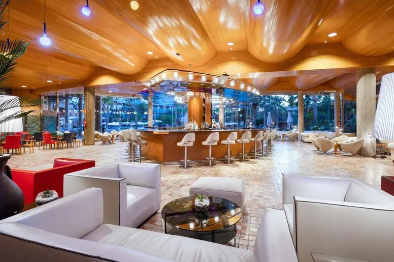 Un grand espace de détente avec un bar et des canapés confortables.