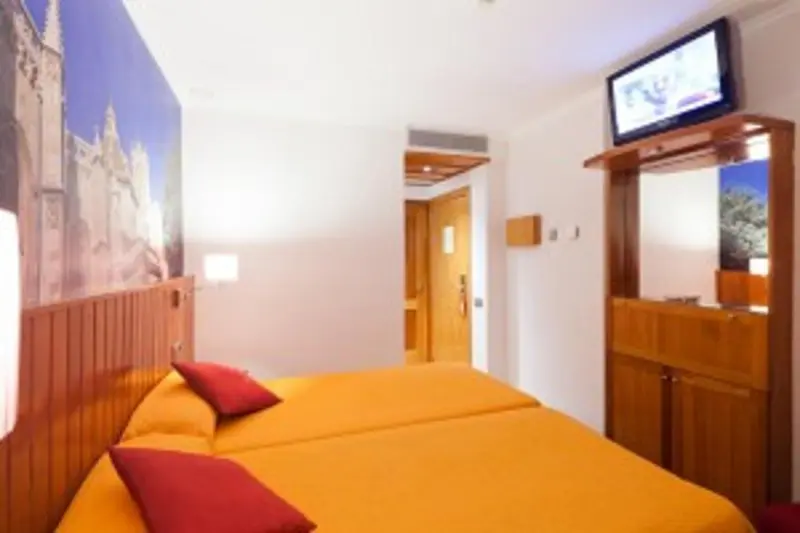 Chambre lumineuse avec deux lits simples et un mur décoré d'une fresque.