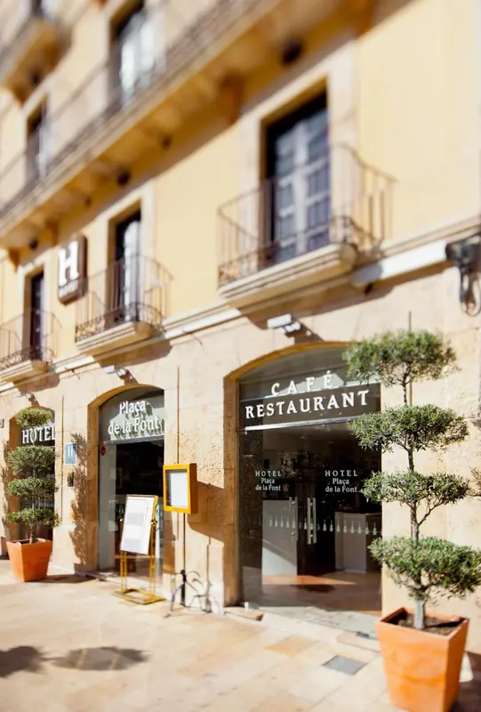 Façade d'un hôtel avec un café restaurant en rez-de-chaussée.