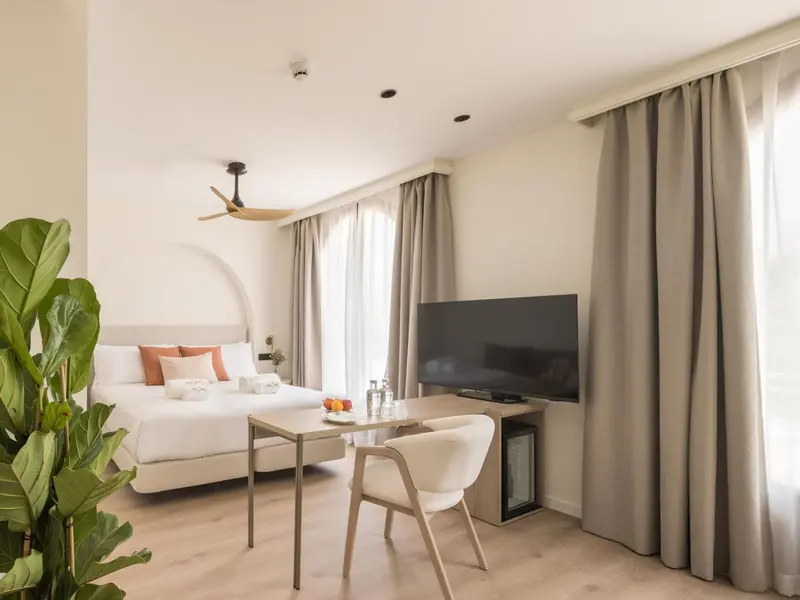 Une chambre lumineuse avec un lit et un coin repas.