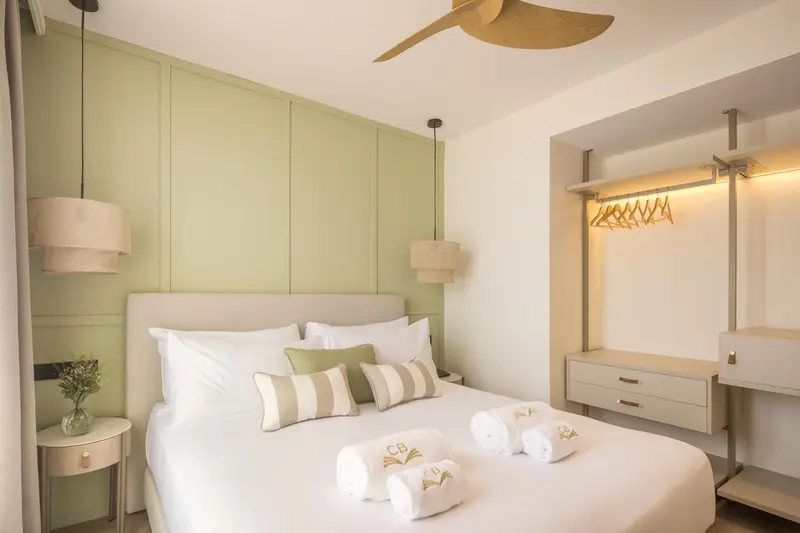 Une chambre lumineuse avec un grand lit et une décoration sobre.