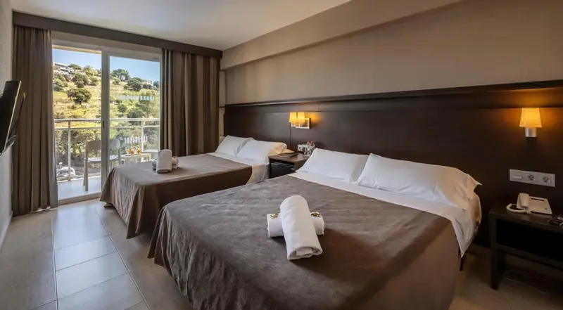 Chambre avec deux lits et vue sur un paysage verdoyant.