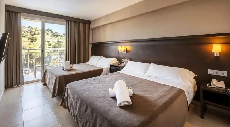 Chambre avec deux lits simples et vue sur un paysage verdoyant.