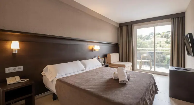 Une chambre lumineuse avec un grand lit et un accès à une terrasse.