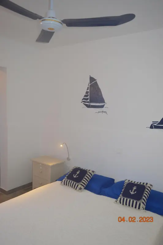 Une chambre lumineuse avec un lit décoré de motifs marins.