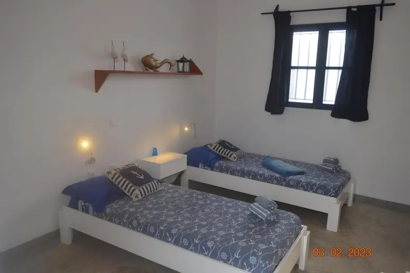 Une chambre avec deux lits simples et une décoration marine.