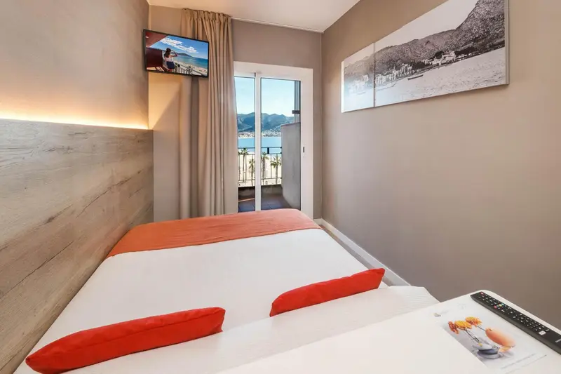 Chambre lumineuse avec un grand lit et une vue sur la mer.