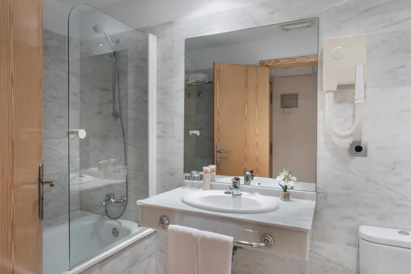 Une salle de bain lumineuse avec une douche et une baignoire.