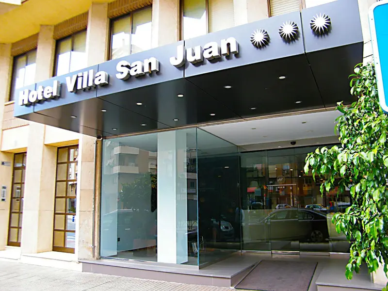 Façade d'un hôtel moderne avec une entrée vitrée et un auvent.