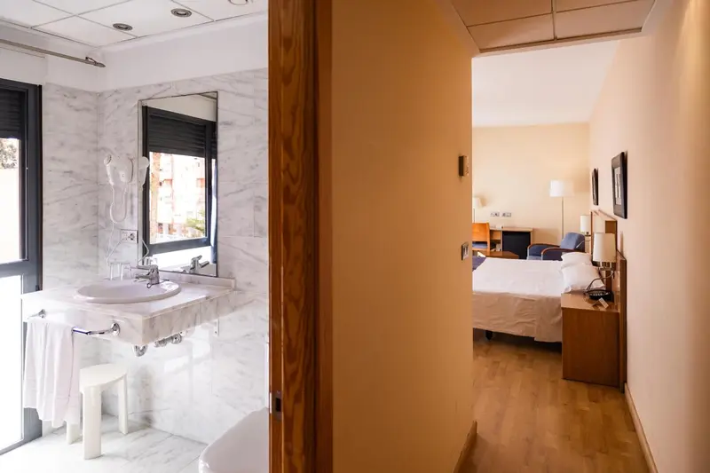 Une salle de bain en marbre et une chambre à coucher lumineuse.