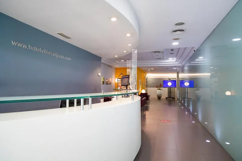 Un comptoir d'accueil moderne dans un hall d'hôtel lumineux.