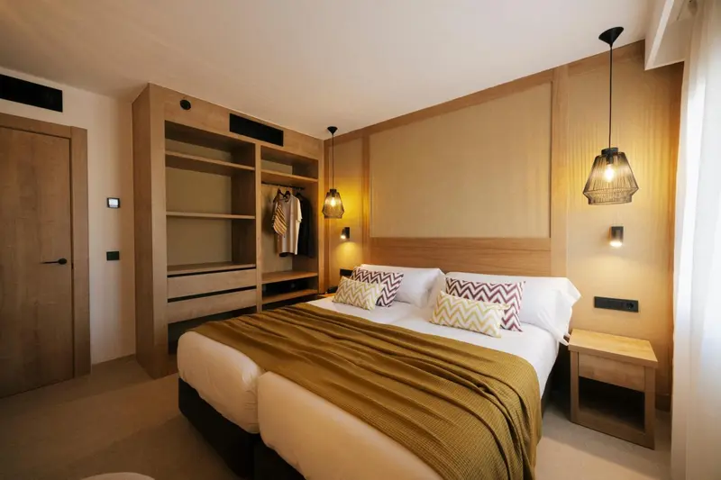 Une chambre à coucher avec un grand lit recouvert d'une couverture et de coussins décoratifs.