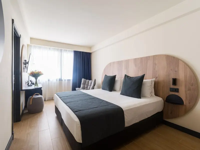 Une chambre lumineuse avec un grand lit et un espace détente.