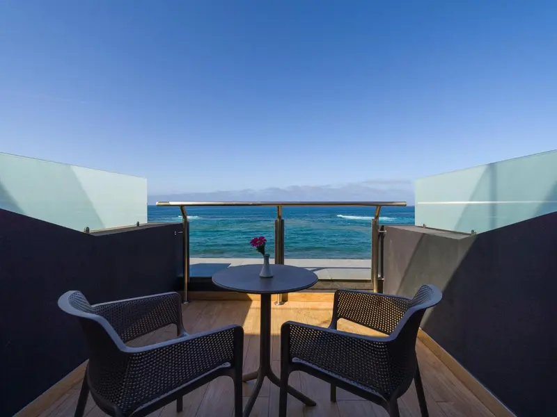 Terrasse avec mobilier d'extérieur donnant sur la mer.