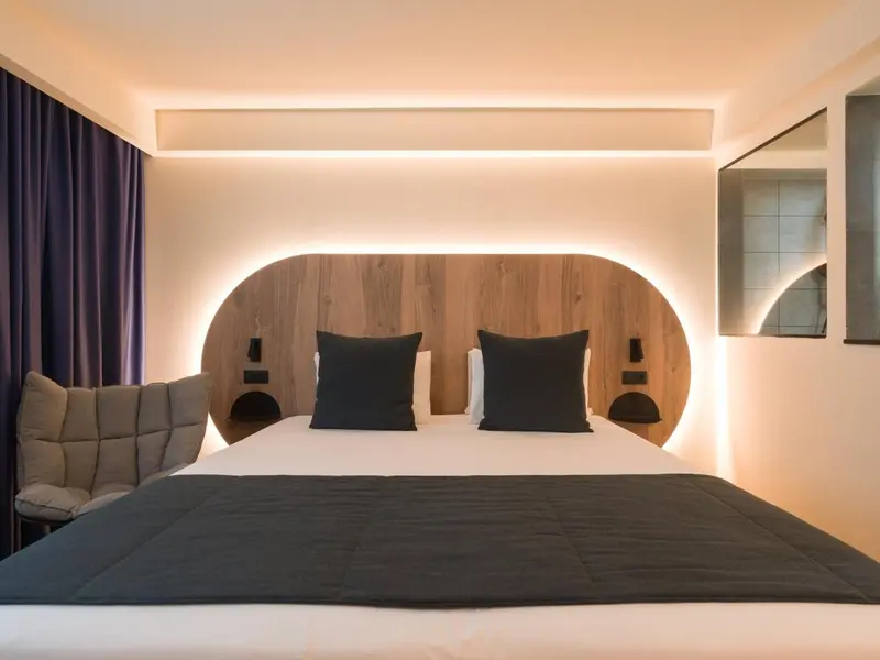 Une chambre moderne avec un grand lit et un éclairage d'ambiance.