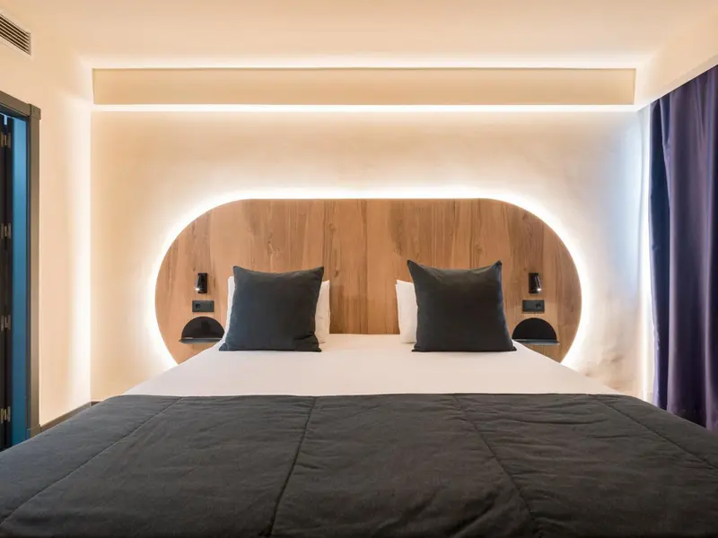 Une chambre moderne avec un grand lit et un éclairage décoratif.