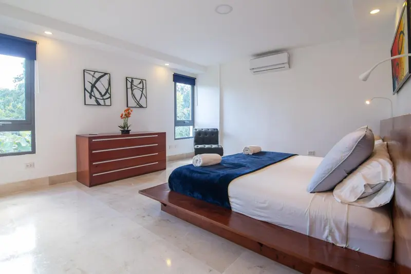 Une chambre lumineuse avec un grand lit et un mobilier en bois.