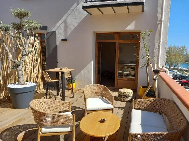 Terrasse aménagée avec mobilier en rotin et table basse.