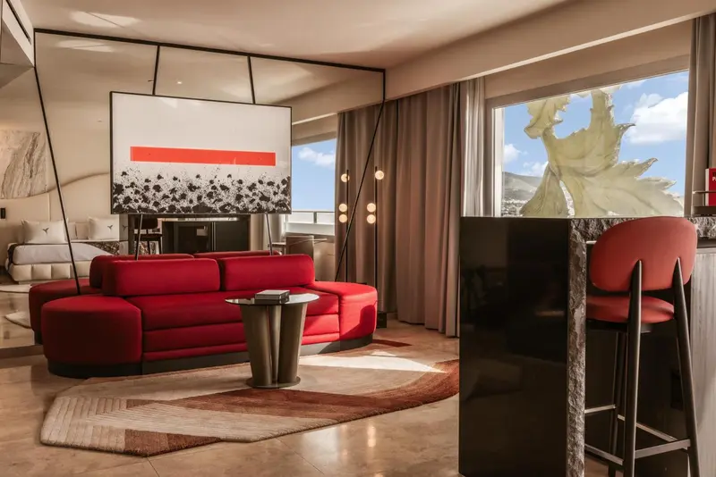 Un salon moderne avec un canapé rouge et un bar noir.