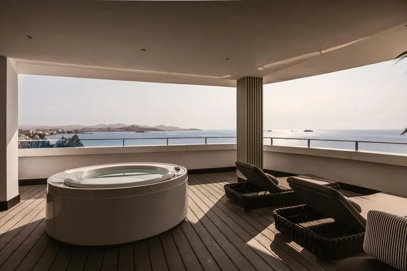 Terrasse avec jacuzzi et chaises longues donnant sur la mer.