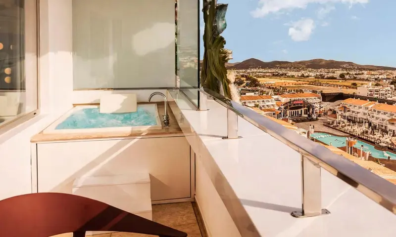 Un jacuzzi extérieur offre une vue sur la ville et la mer.