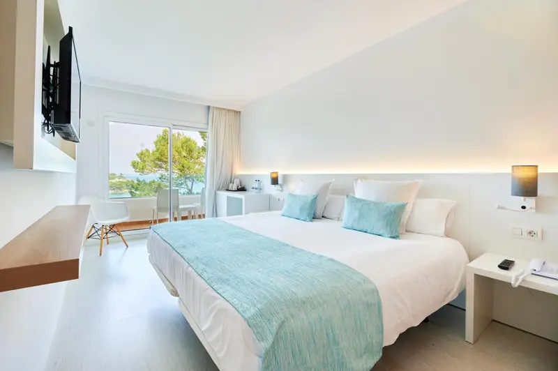 Une chambre lumineuse avec un grand lit et une vue sur la mer.