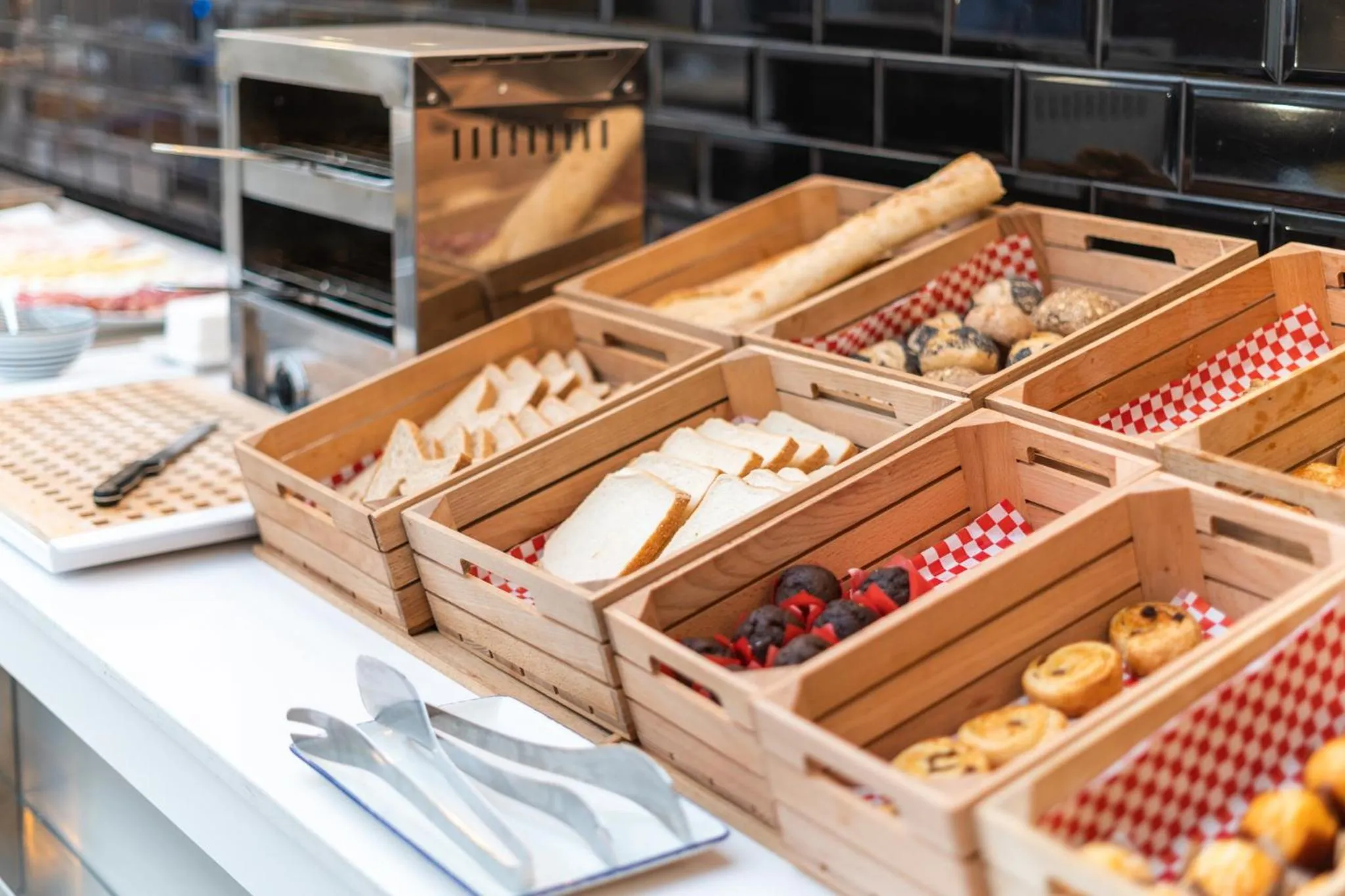 Présentation de viennoiseries et de pains variés sur un buffet.