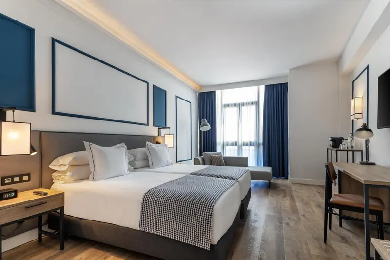 Une chambre d'hotel avec un grand lit et un bureau.