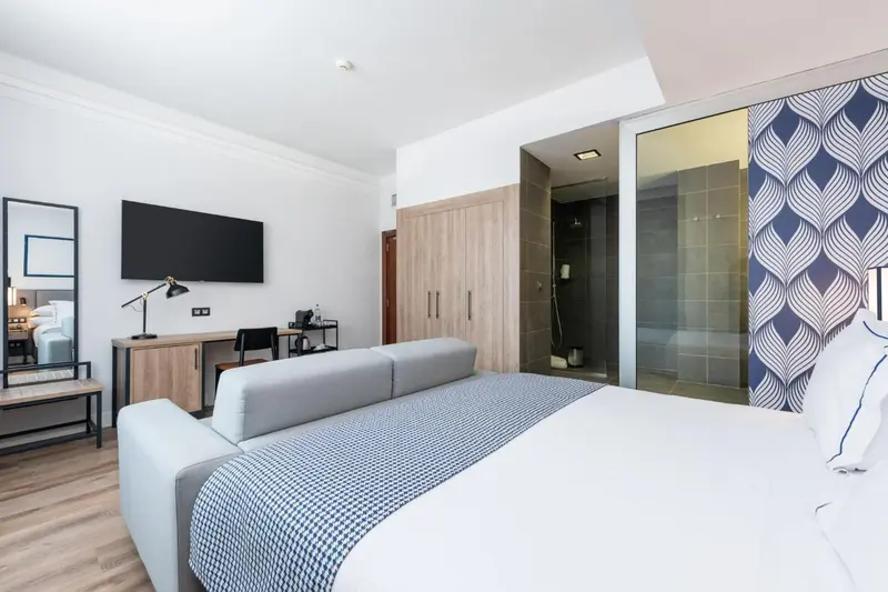 Une chambre lumineuse avec un lit et un espace détente.