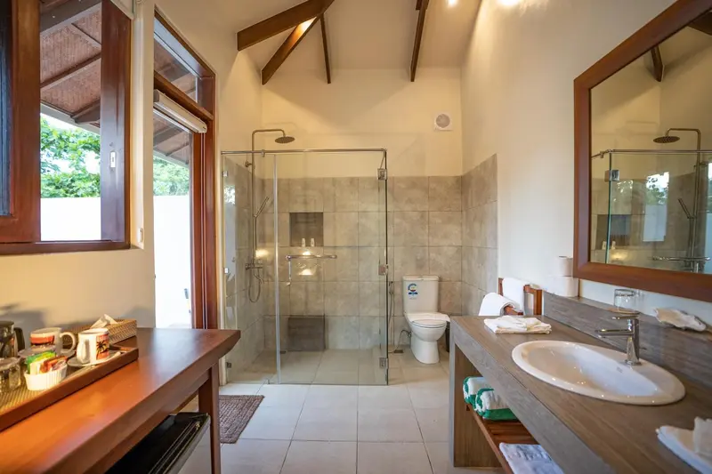 Une salle de bain lumineuse avec douche à l'italienne et double vasque.