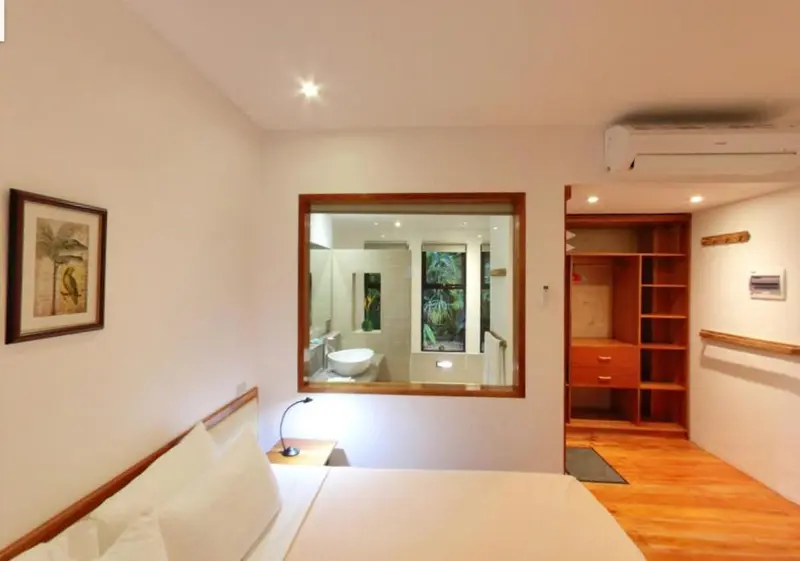 Une chambre lumineuse avec un lit et un accès à une salle de bain.