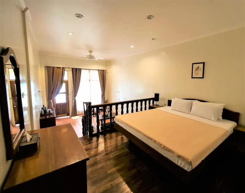 Une chambre spacieuse avec un grand lit et un bureau en bois.