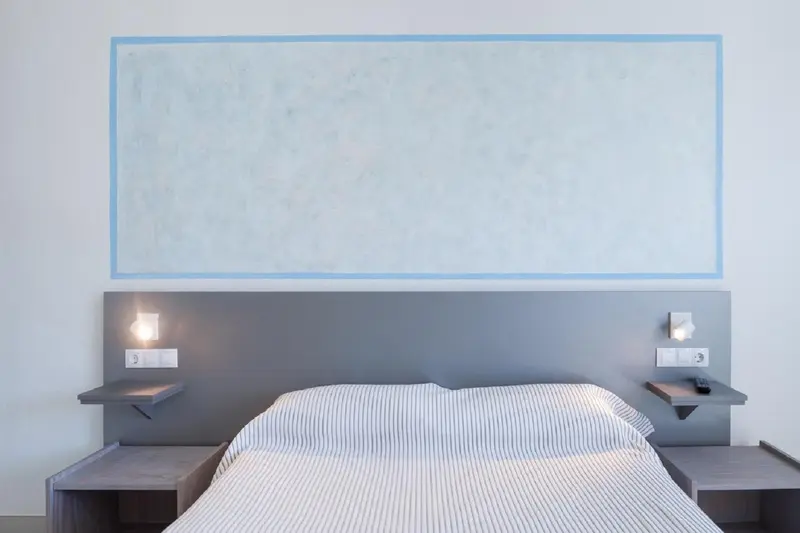 Un lit double avec des oreillers blancs dans une chambre moderne.