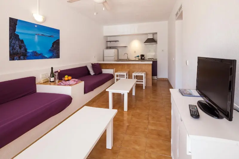 Interieur lumineux avec coin salon et cuisine ouverte.